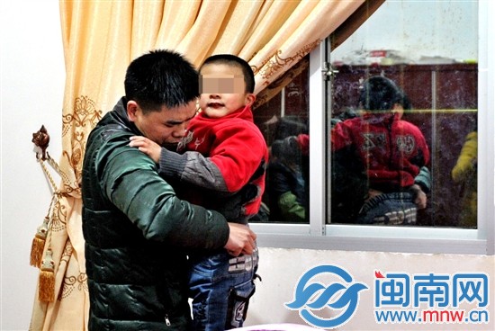 爸爸許先生，為玩鬧的小兒子整理褲子