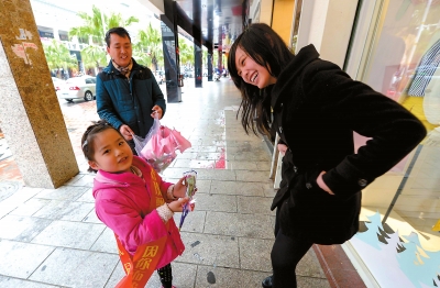 趙藍(lán)靈小朋友給街上的女士送上玫瑰花