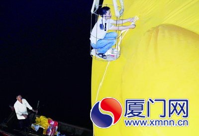 工人給大黃鴨系上繩子，準備起吊