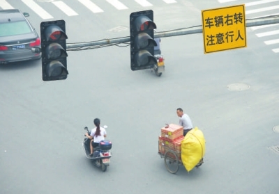 闖紅燈、不戴頭盔現(xiàn)象時有發(fā)生。本報記者陳明哲攝