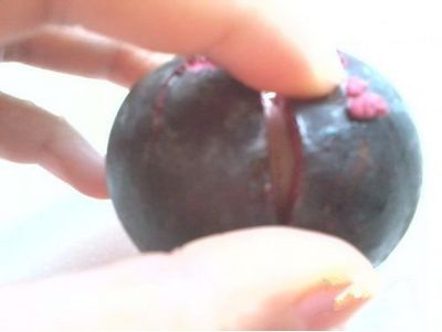 用菜刀，沿著其中兩瓣果肉的縫隙切下去