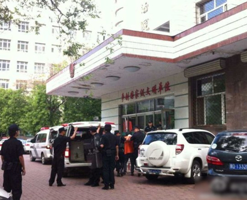 兩名犯罪嫌疑人頭戴面罩，被法警押進(jìn)法庭。2