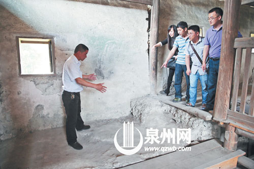許進丁向游客們比劃著土樓墻體的厚度，當年建造土樓