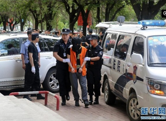 兩名犯罪嫌疑人頭戴面罩，被法警押進法庭。
