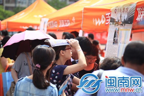 海都咨詢會(huì)現(xiàn)場(chǎng)，一名家長(zhǎng)頂著烈日看學(xué)校信息
