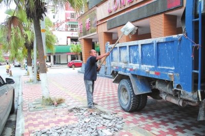 在市區(qū)長安街，工人正在清理路面修補后遺留下來的垃