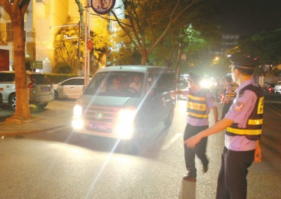 交警攔下濫開遠(yuǎn)光燈車輛。本報(bào)記者朱晨輝攝